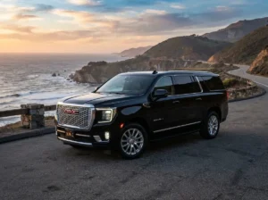 A sleek black GMC Yukon Denali luxury SUV parked on a scenic road, representing premium airport transfer services between Toronto and Buffalo.