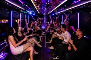 Lively group of friends celebrating inside a luxury party bus with purple neon lighting